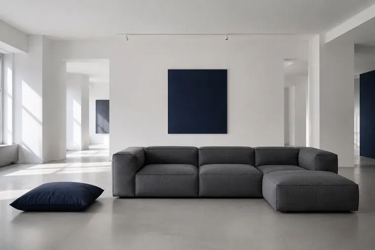 Sofá modular en tela gris grafito con chaise longue y cojín azul navy